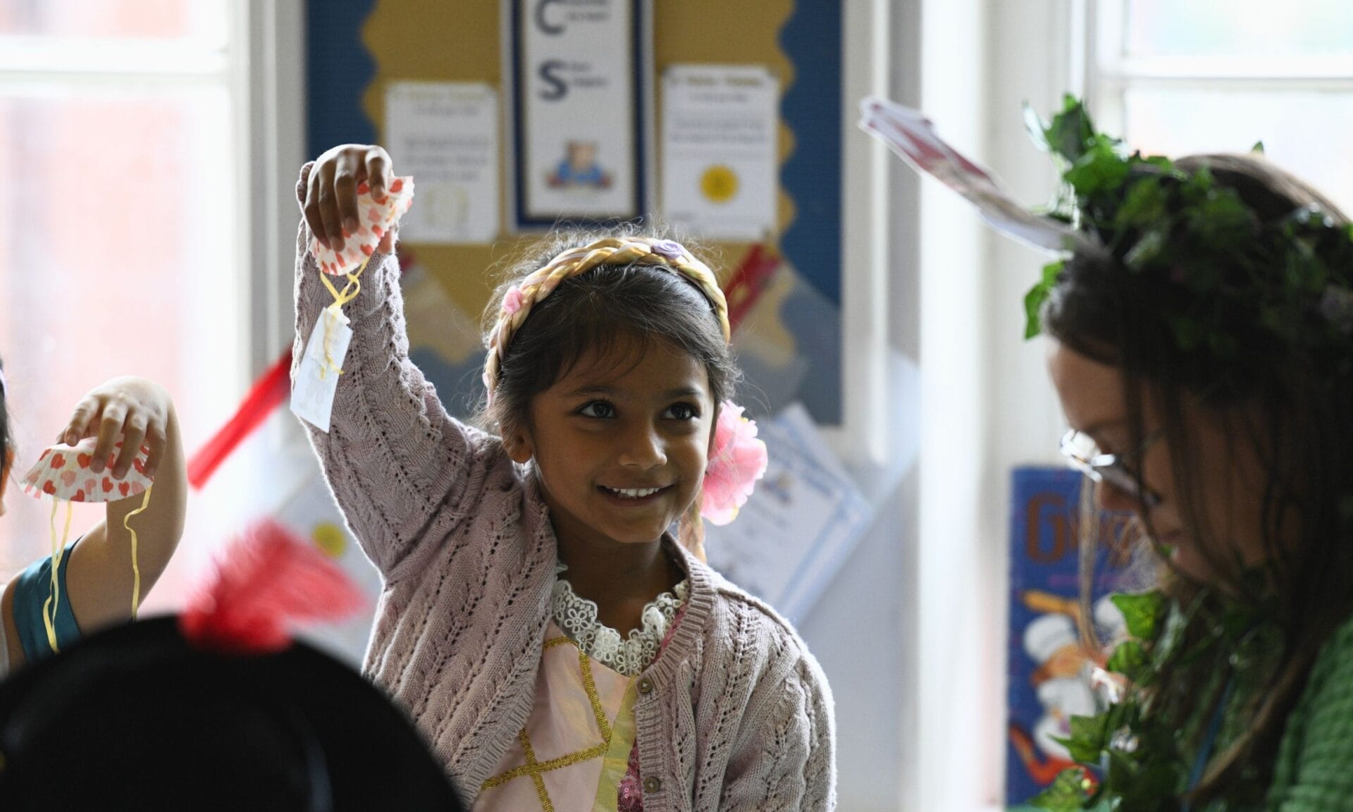 A young girl holds a homemade parachute before letting it go on her enrichment day.