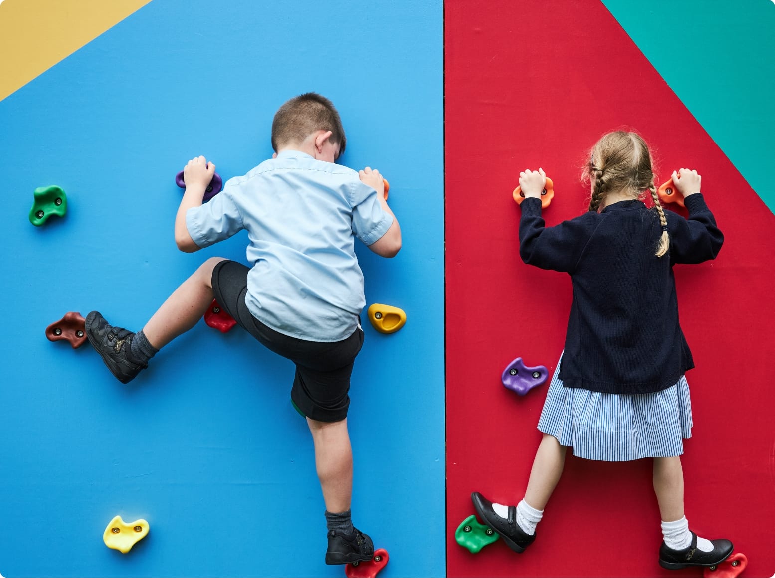 A boy and a girl climb on the climbing wall.