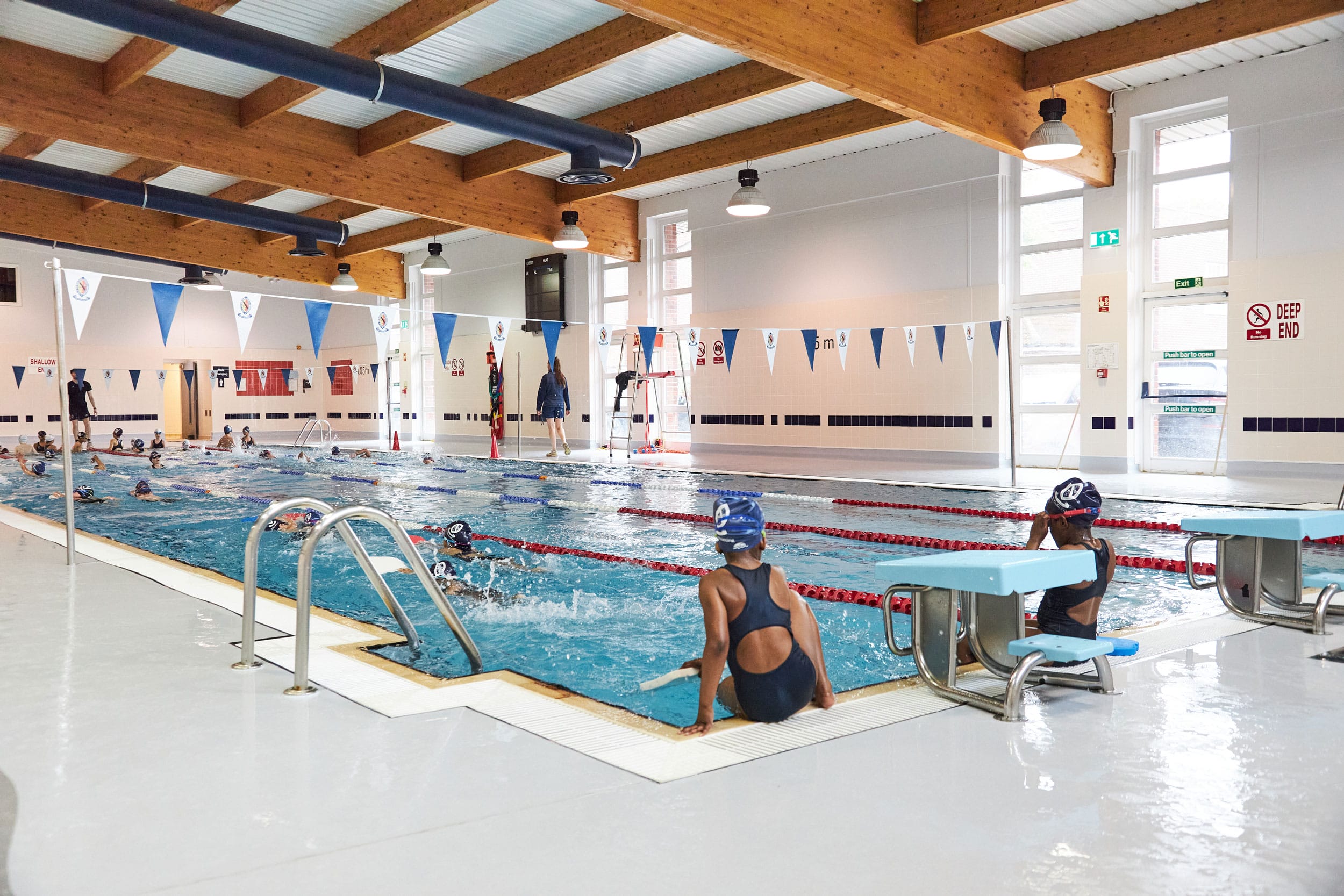 A girls sits on the side of the 25-metre swimming pool at The Blue Coat School.