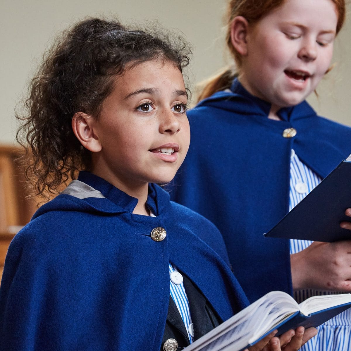 A girl singing from a hymn book in The Blue Coat School Chapel.