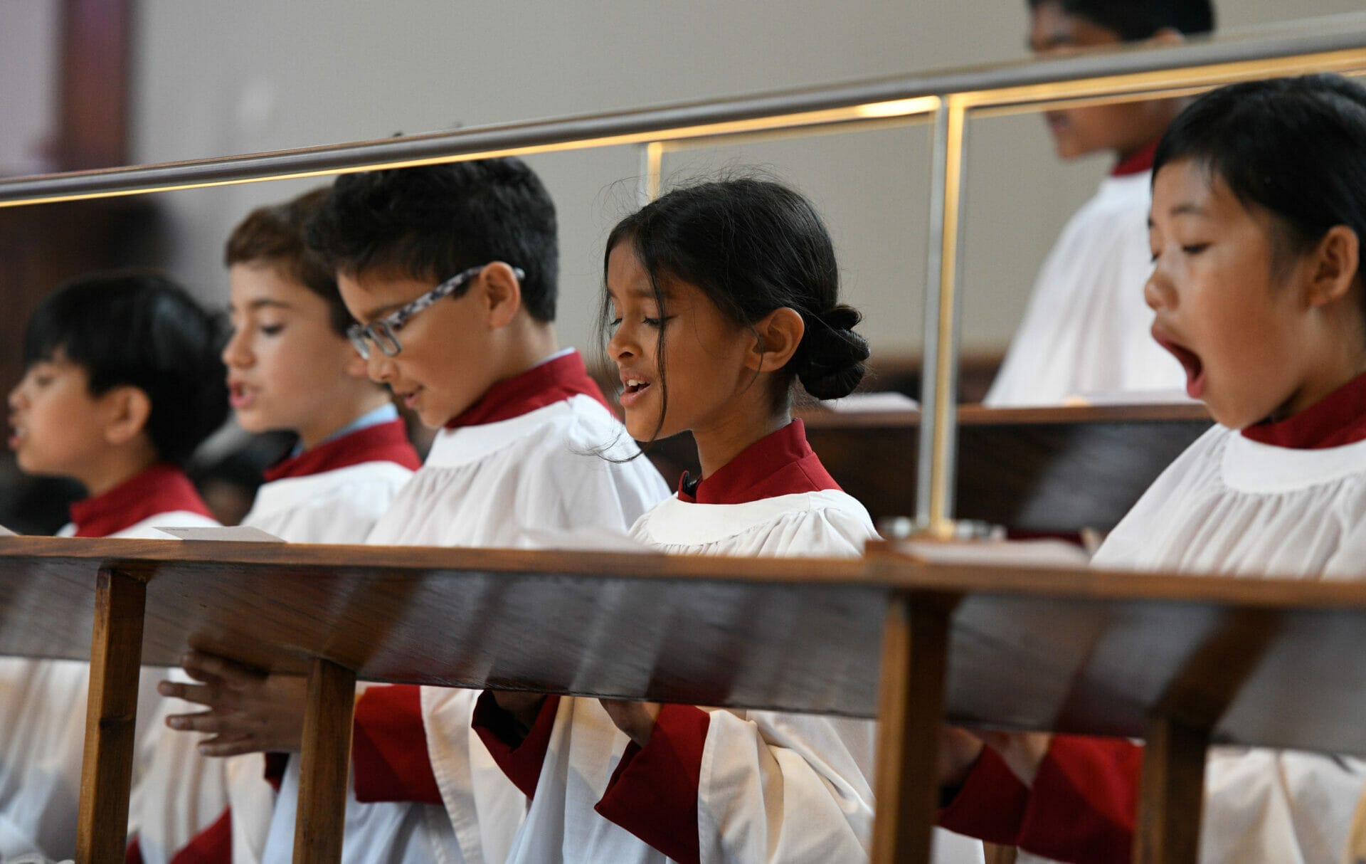 The Chapel Choir singing in their red and white robes in The Blue Coat School Chapel