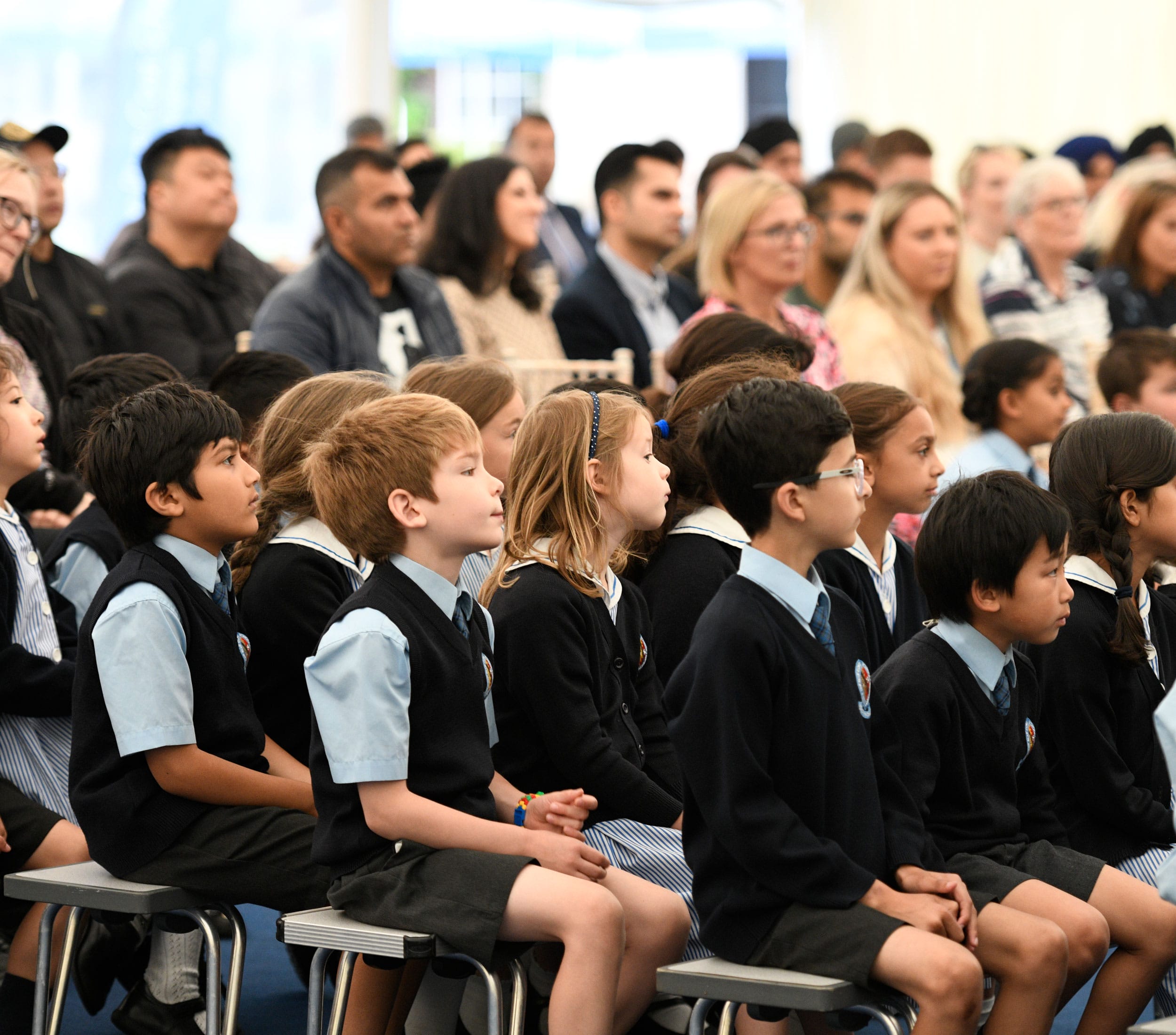 Children and parents gather in a marquee for the Year 2 BCS Blue presentation ceremony.