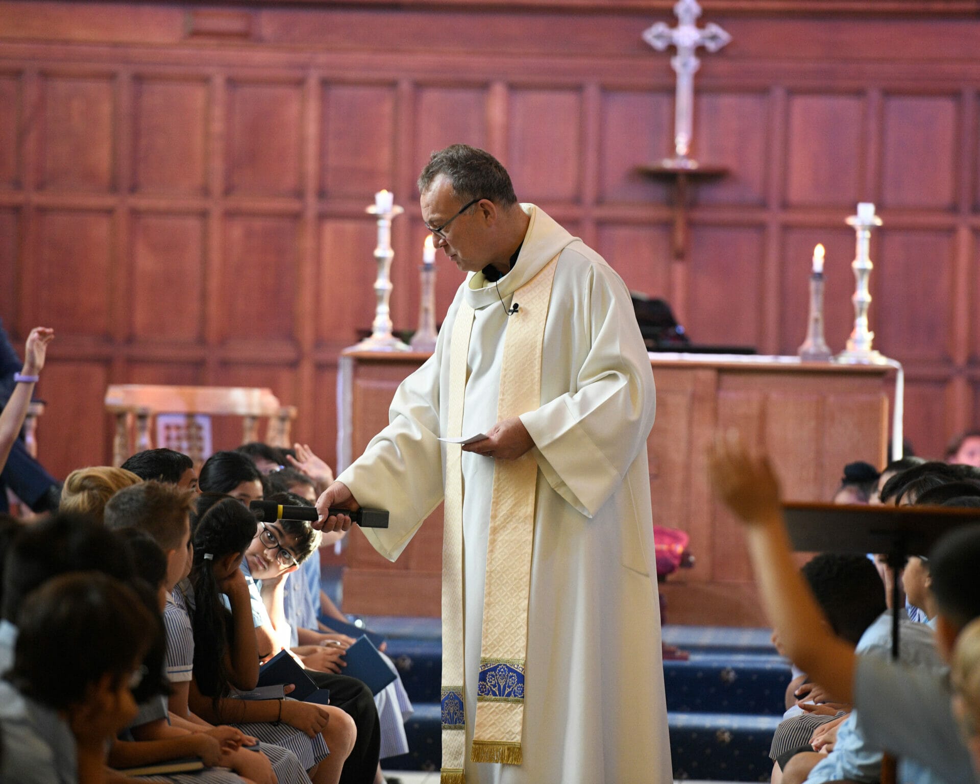 Father Andrew speaks to pupils during a Chapel service.