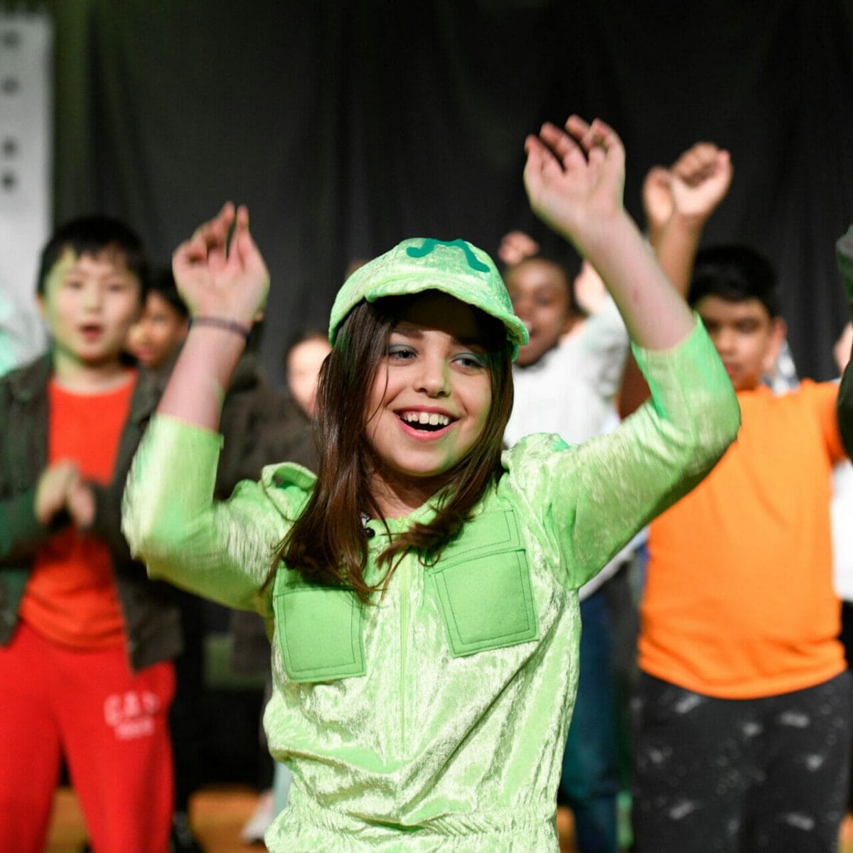 A girl dancing with her arms in the air during the Year 4 Production.
