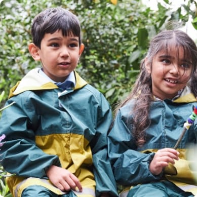 A boy and a girl sat together in Forest School