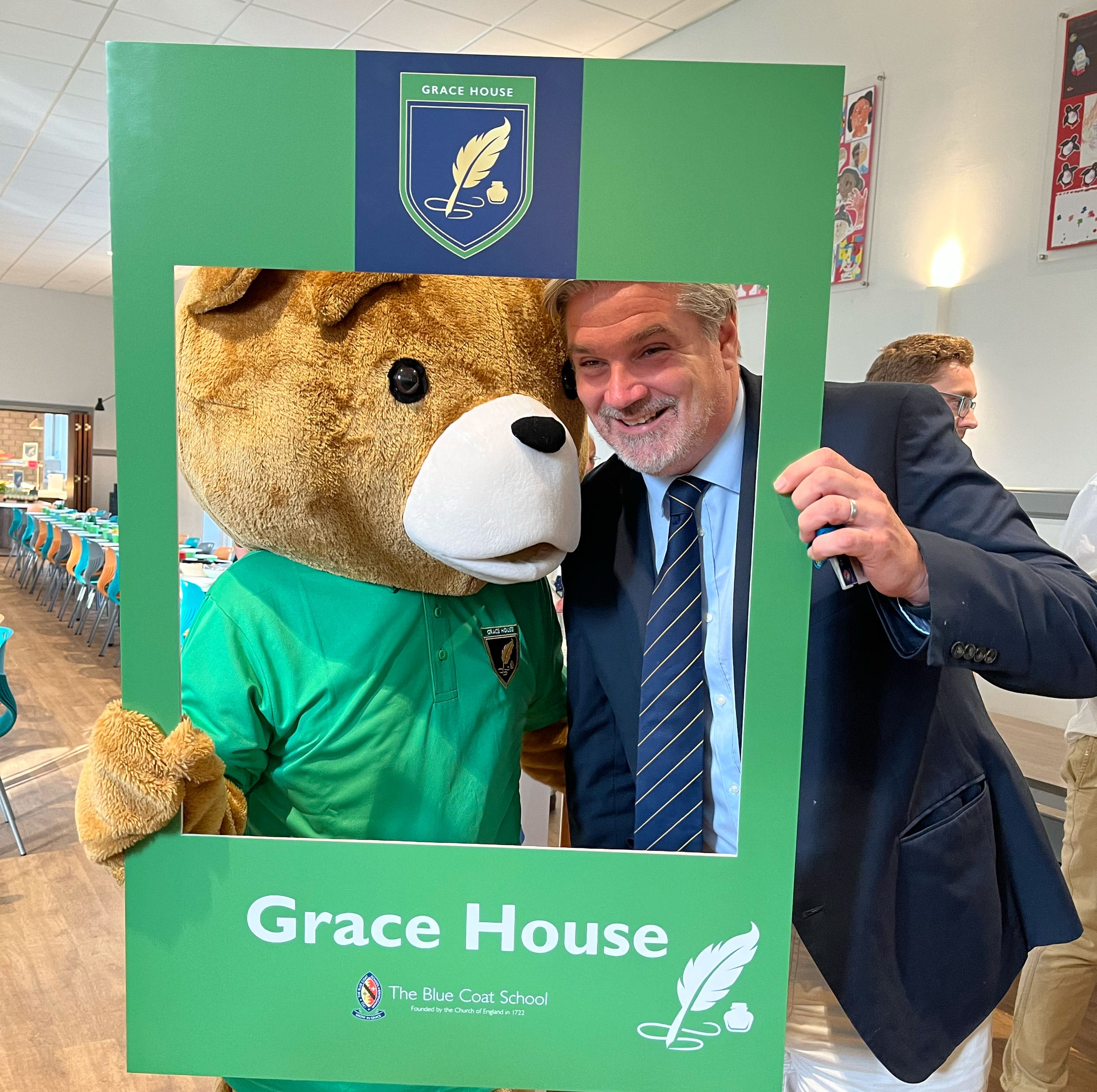 Headmaster, Noel Neeson poses for a photo in the Grace House selfie frame with Bluey the Bear.