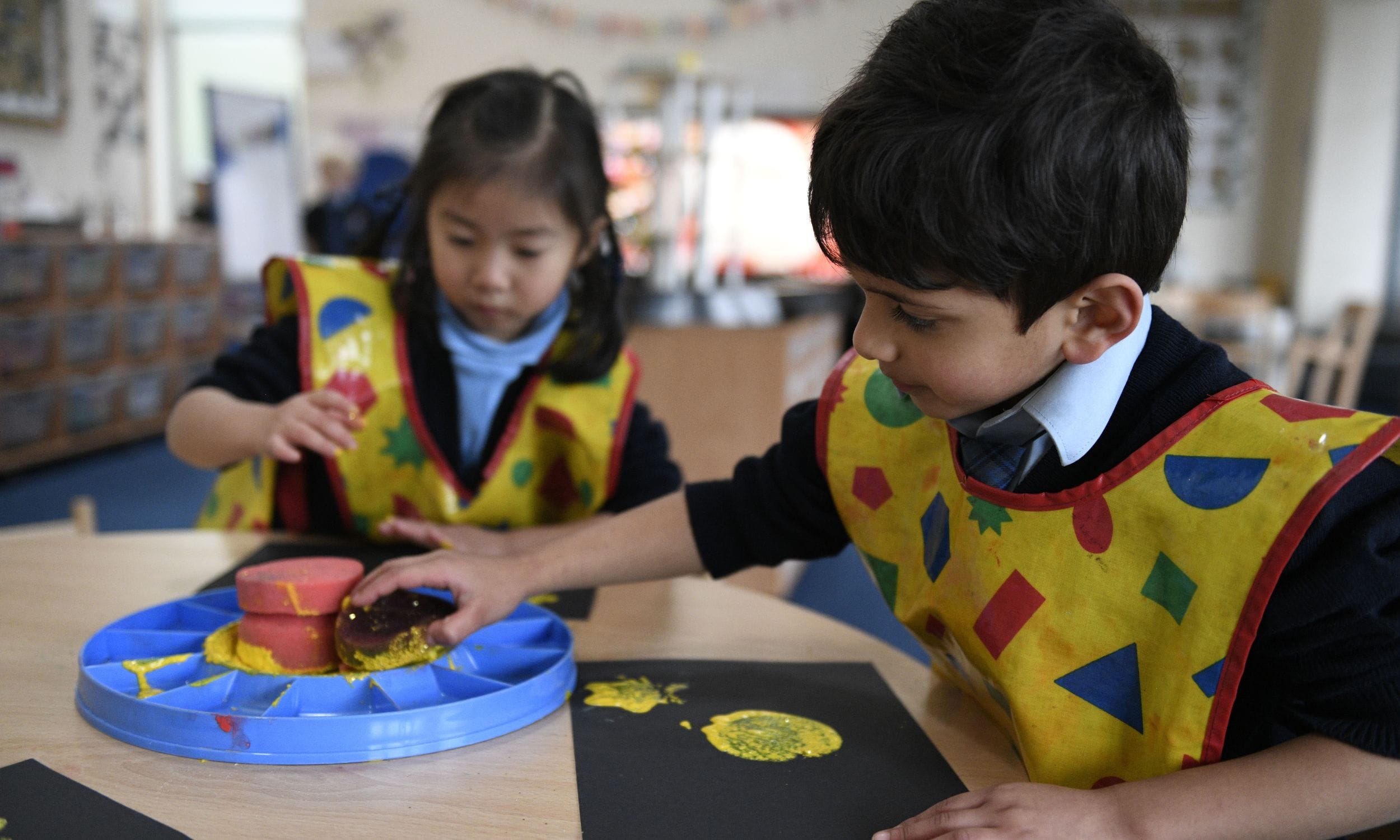A girl and a boy making artwork together in class