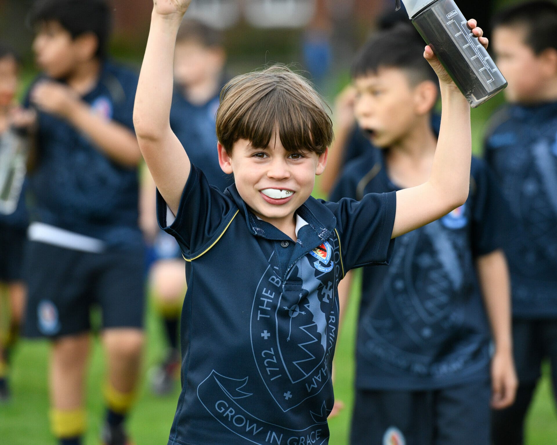 A young boy celebrates after a successful rugby fixture.
